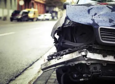 pictured damage as the result of a hit and run to a blue car on a street