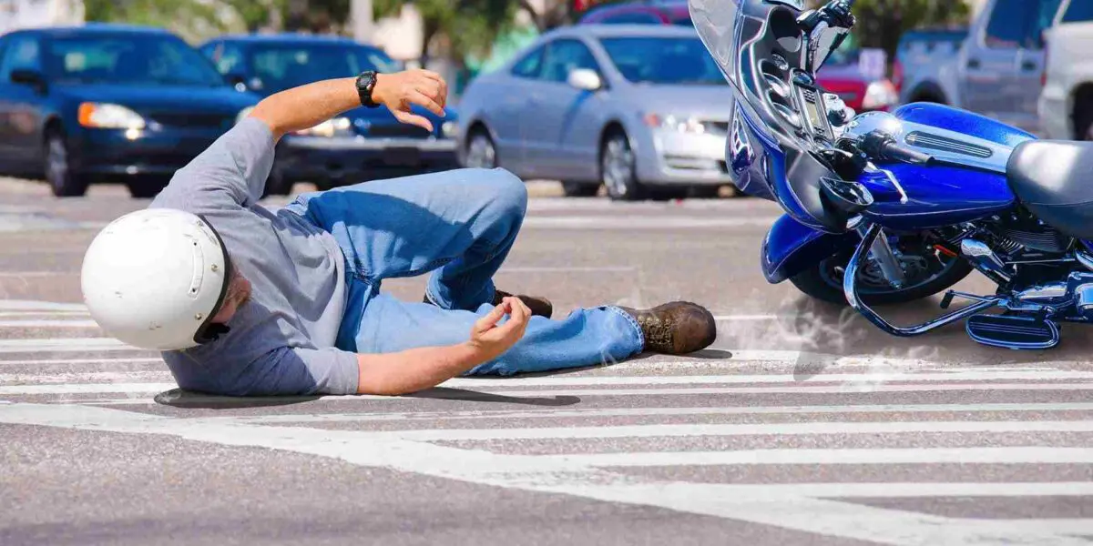 Man falling off blue motorcycle after being hit, involved in a motorcycle accident
