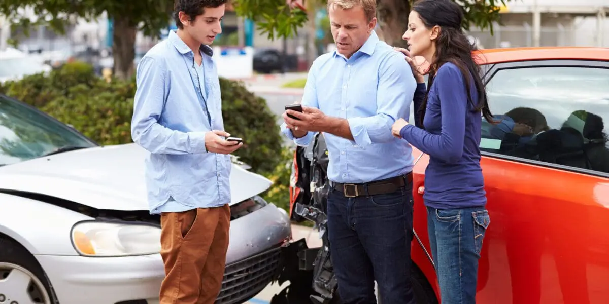 three people talking at the scene of a multiple-party car accident