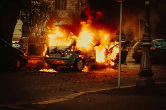 car engulfed in flames on side of road