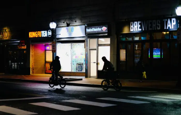 pedestrians crossing a crosswalk at night