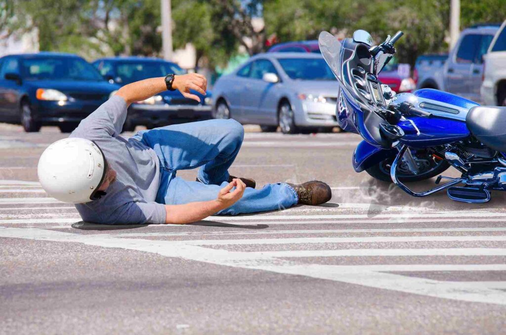 Man falling off blue motorcycle after being hit, involved in a motorcycle accident