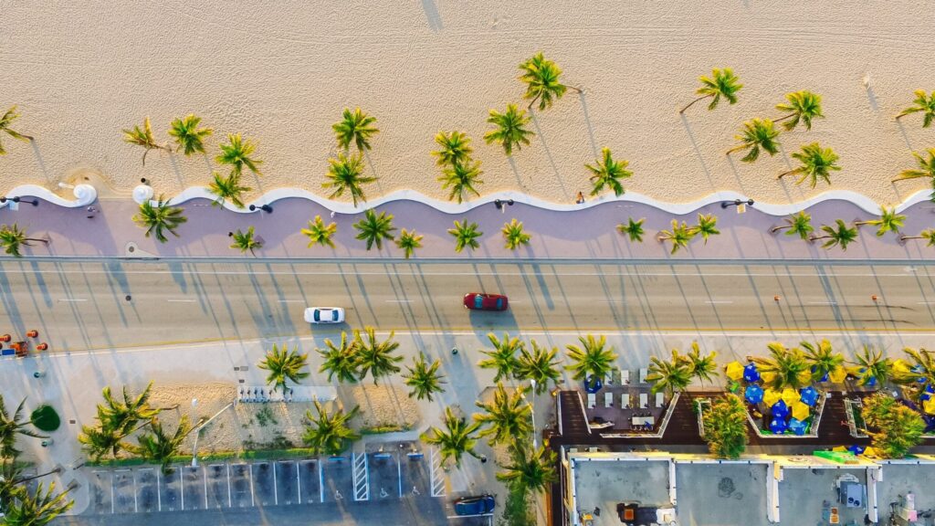 Picturesque arial view of Florida's A1A roadway with cars driving next to palm trees and beach