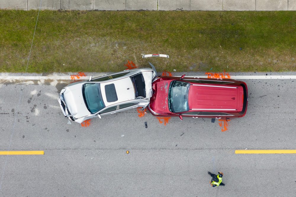 A two-vehicle car crash at an intersection showing both cars damaged at the accident scene